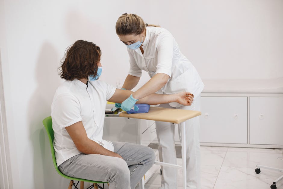A nurse aids a patient during a medical procedure in a clinical setting.